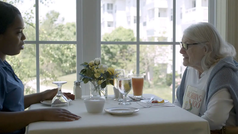 senior converses with woman across the table