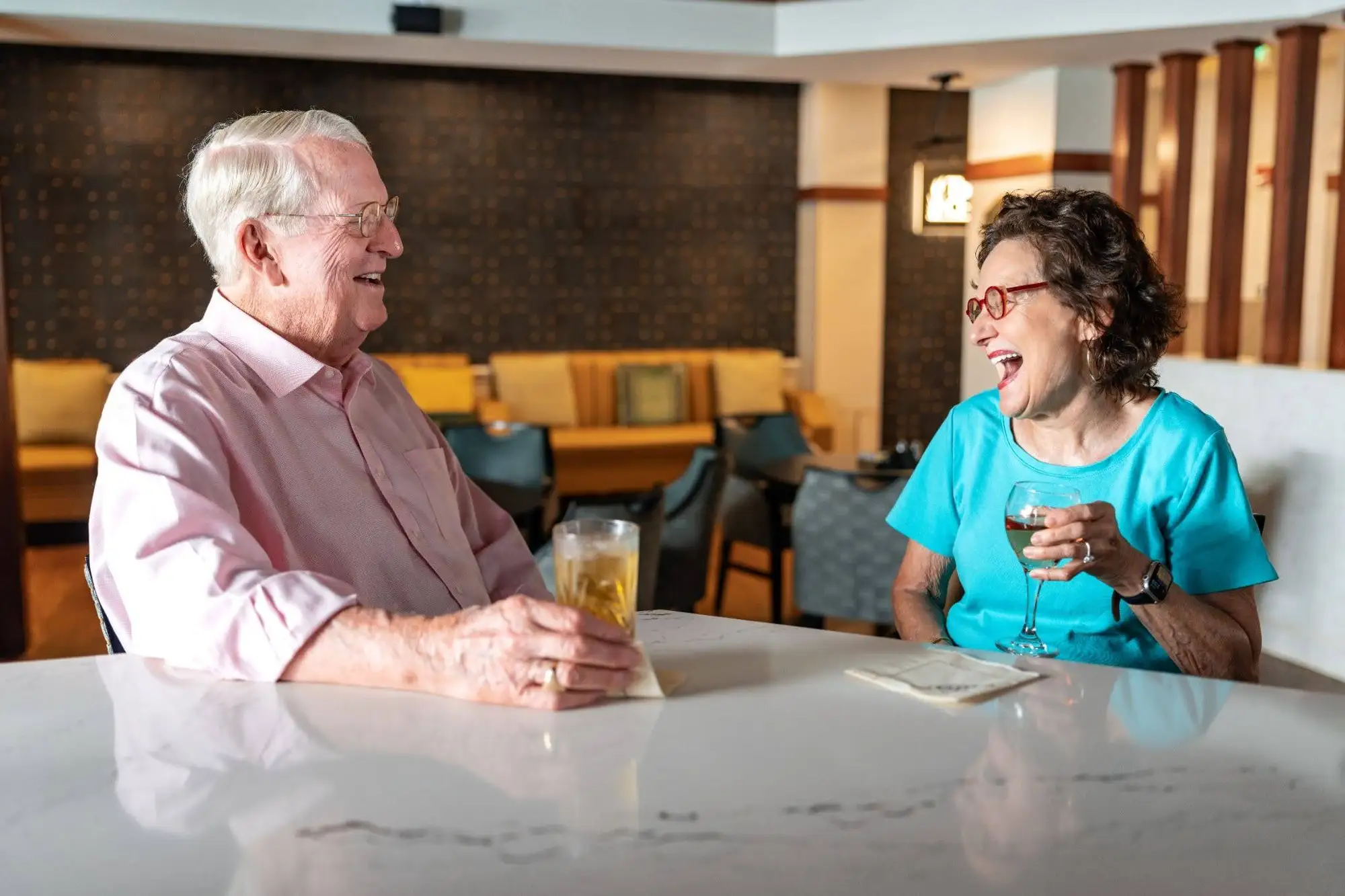 An image of a happy senior resident couple of Blakehurst in Towson, MD enjoying the dining venues like The Chesapeake.