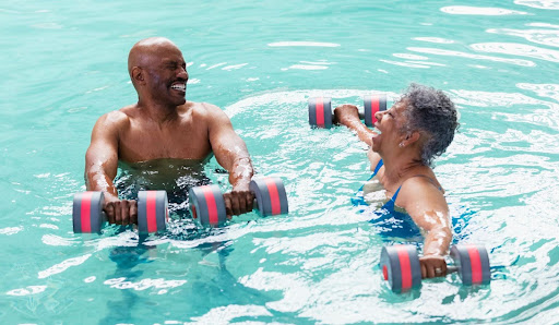 Two seniors doing arm exercises in pool