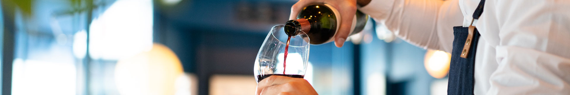 staff pours wine into a glass