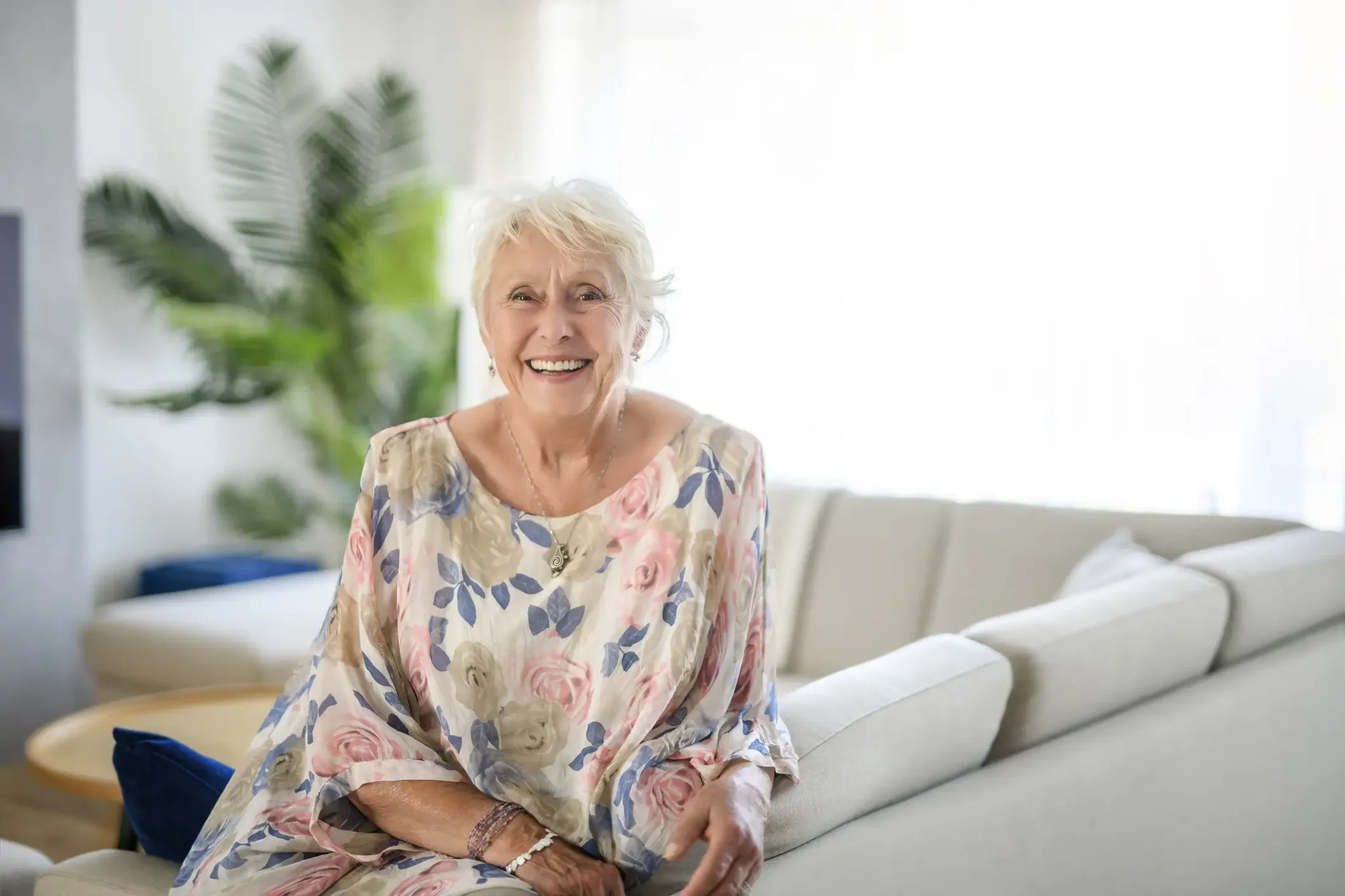 Senior woman sitting on her couch in her senior living apartment